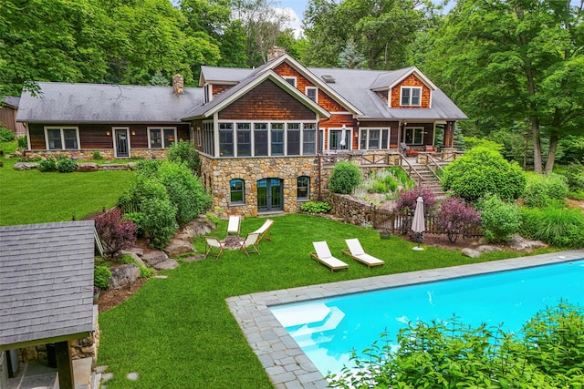 17 Half Moon Rdg, Cold Spring, NY 10516 - back of house featuring stone siding, a chimney, an outdoor pool, a lawn, and french doors