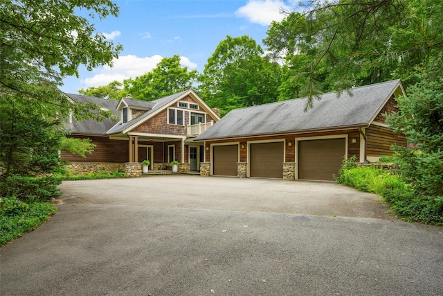 17 Half Moon Rdg, Cold Spring, NY 10516 - view of front of house featuring a porch, driveway, an attached garage, stone siding, and roof with shingles