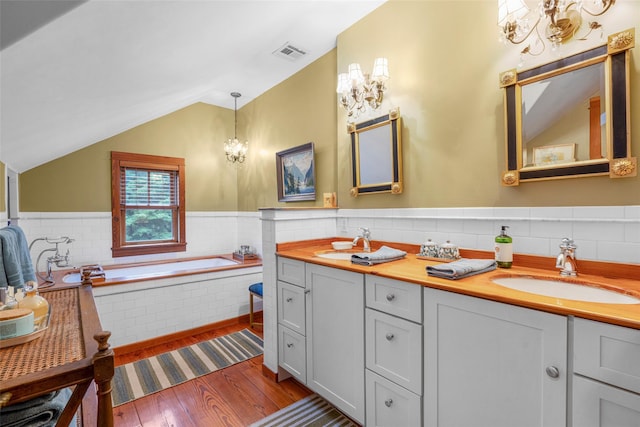 17 Half Moon Rdg, Cold Spring, NY 10516 - full bathroom featuring a chandelier, lofted ceiling, wood finished floors, tile walls, and double vanity