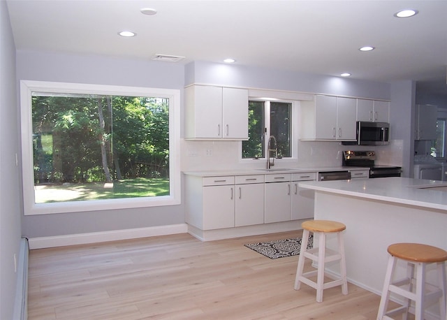 121 Lower Sheep Pasture Rd, East Setauket, NY 11733 - kitchen featuring stainless steel microwave, electric range, light countertops, backsplash, and recessed lighting
