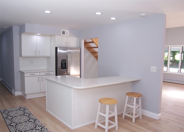 121 Lower Sheep Pasture Rd, East Setauket, NY 11733 - kitchen with stainless steel fridge with ice dispenser, light wood finished floors, a baseboard radiator, white cabinets, and recessed lighting