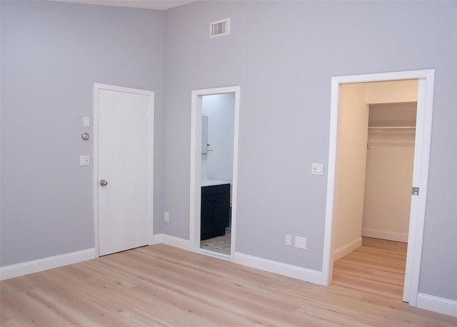 121 Lower Sheep Pasture Rd, East Setauket, NY 11733 - unfurnished bedroom with light wood-type flooring, a walk in closet, and ensuite bath