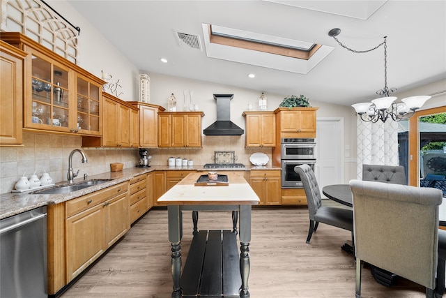 506 Kime Ave, West Islip, NY 11795 - kitchen featuring wall chimney exhaust hood, appliances with stainless steel finishes, a chandelier, a skylight, and vaulted ceiling