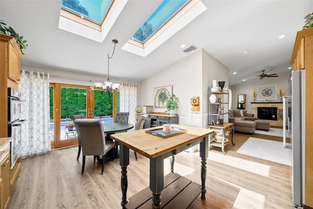 506 Kime Ave, West Islip, NY 11795 - dining area with a chandelier, vaulted ceiling, light wood-style floors, a skylight, and a fireplace