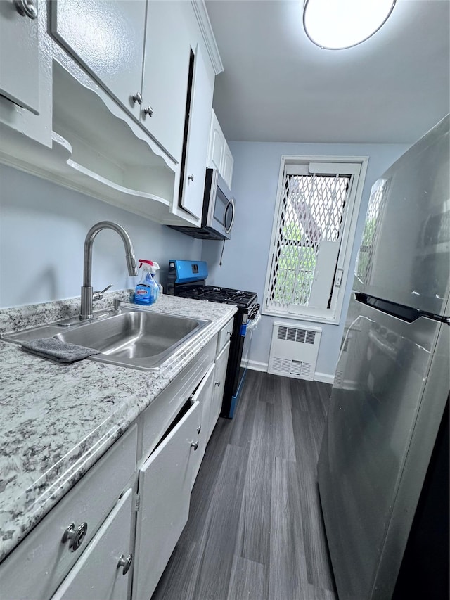 33-24 Junction Blvd Unit 6R, Jackson Heights, NY 11372 - kitchen with appliances with stainless steel finishes, dark wood-style floors, and white cabinets