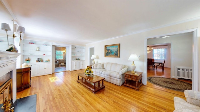 32 Biltmore Ave, Yonkers, NY 10710 - living area featuring light wood finished floors, radiator heating unit, crown molding, a fireplace with flush hearth, and built in features