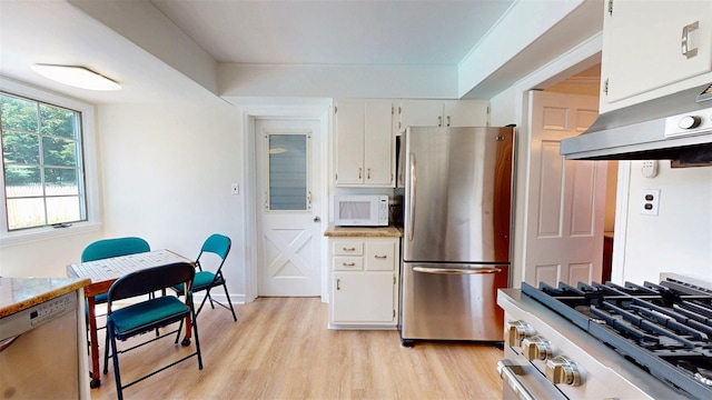32 Biltmore Ave, Yonkers, NY 10710 - kitchen featuring appliances with stainless steel finishes, ventilation hood, light wood-style floors, and white cabinets