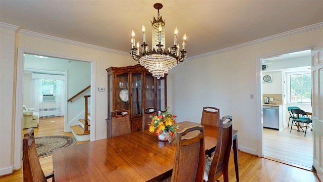 32 Biltmore Ave, Yonkers, NY 10710 - dining space with radiator heating unit, light wood-style floors, stairway, a chandelier, and crown molding