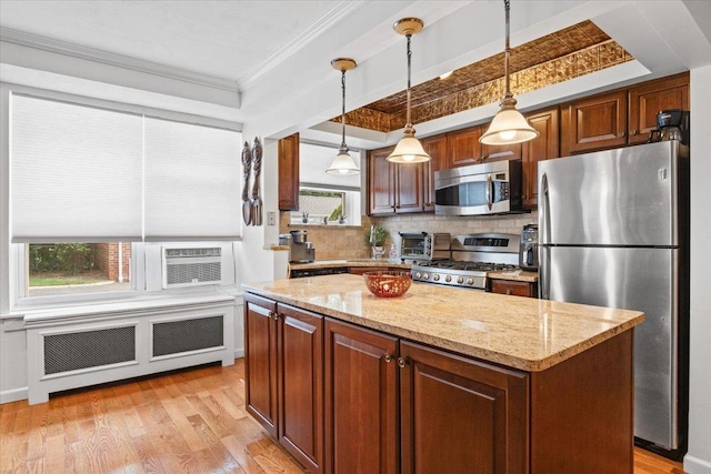 81 Edwards St Unit T, Roslyn Heights, NY 11577 - kitchen with appliances with stainless steel finishes, crown molding, radiator, a kitchen island, and light wood-type flooring