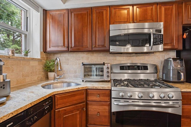 81 Edwards St Unit T, Roslyn Heights, NY 11577 - kitchen with appliances with stainless steel finishes, backsplash, light stone countertops, and brown cabinetry
