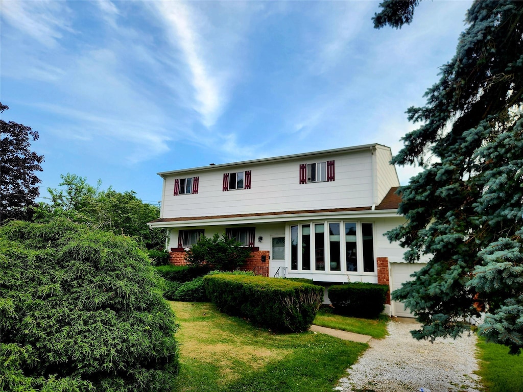 14 Brian Dr, East Islip, NY 11730 - traditional-style home featuring dirt driveway, brick siding, and a front lawn
