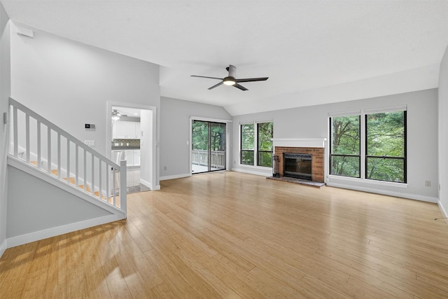 582 Heritage Hls Unit A, Somers, NY 10589 - unfurnished living room with a ceiling fan, stairway, light wood-style floors, a fireplace, and vaulted ceiling