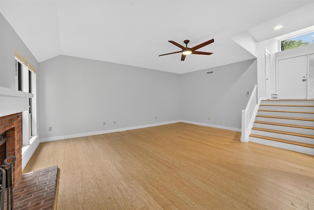 582 Heritage Hls Unit A, Somers, NY 10589 - unfurnished living room featuring a fireplace, a ceiling fan, stairs, wood finished floors, and vaulted ceiling