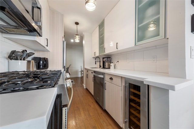 6 Birchwood Ct Unit 4C, Mineola, NY 11501 - kitchen featuring stainless steel appliances, wine cooler, tasteful backsplash, and light countertops