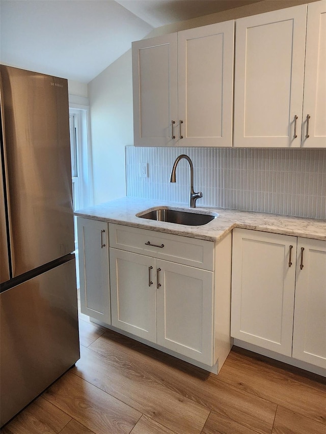 117 Talmadge St, Poughkeepsie, NY 12601 - kitchen featuring freestanding refrigerator, light wood-style floors, tasteful backsplash, and light stone counters