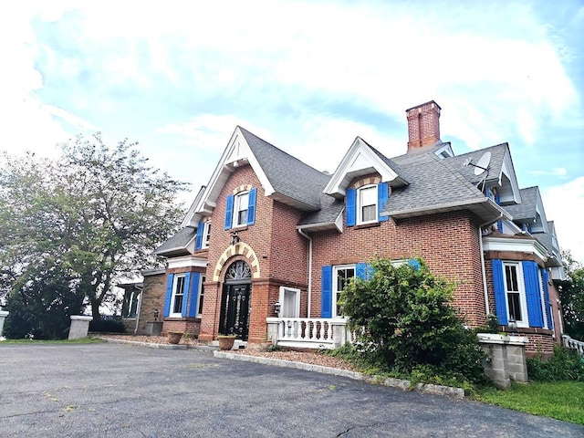 12 Monell Pl, Beacon, NY 12508 - view of front of property with roof with shingles, brick siding, and a chimney