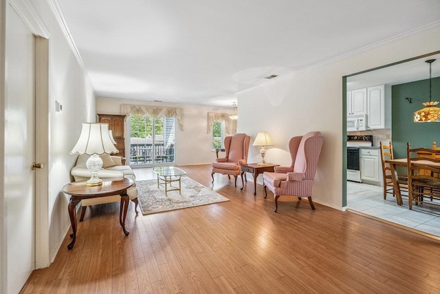 914 Fenway Rd, Saint James, NY 11780 - living room featuring light wood-type flooring, a chandelier, and ornamental molding