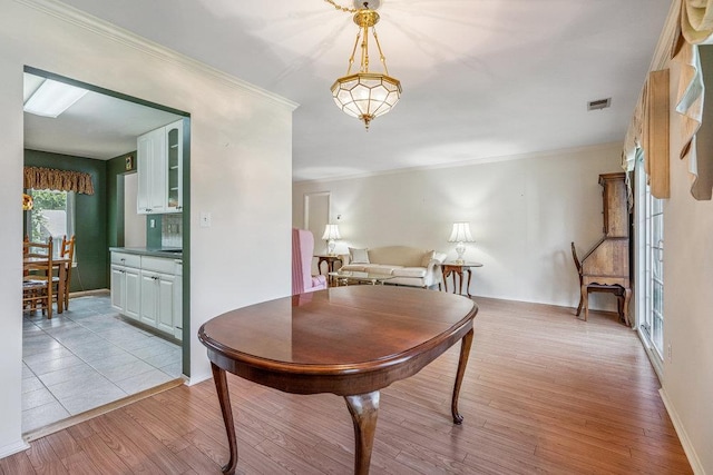 914 Fenway Rd, Saint James, NY 11780 - dining space with light wood-style flooring and crown molding