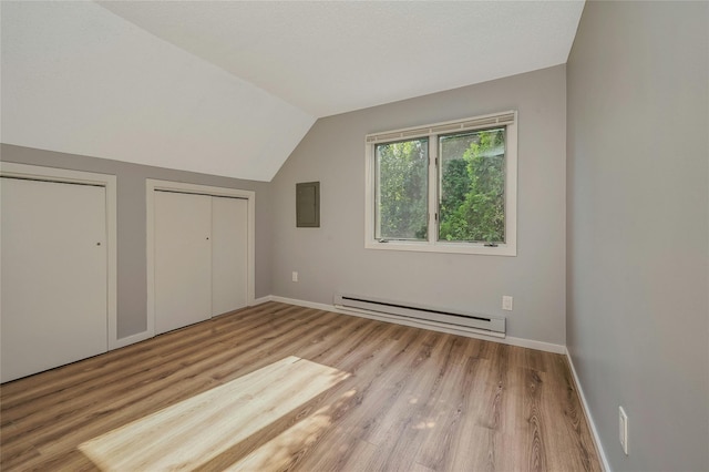 31 Neptune Ave, Mastic, NY 11950 - unfurnished bedroom with baseboard heating, multiple closets, wood finished floors, vaulted ceiling, and electric panel