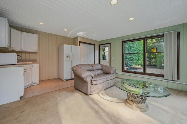 31 Neptune Ave, Mastic, NY 11950 - living area featuring light colored carpet, recessed lighting, light tile patterned floors, and wooden walls