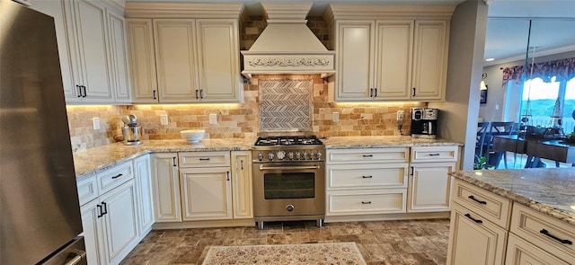 12 Omni Parc Dr, Nanuet, NY 10954 - kitchen with appliances with stainless steel finishes, custom range hood, cream cabinetry, and tasteful backsplash