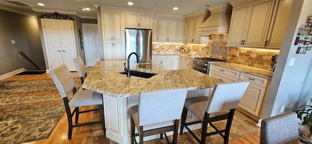 12 Omni Parc Dr, Nanuet, NY 10954 - kitchen featuring appliances with stainless steel finishes, premium range hood, recessed lighting, light stone countertops, and light wood-style floors