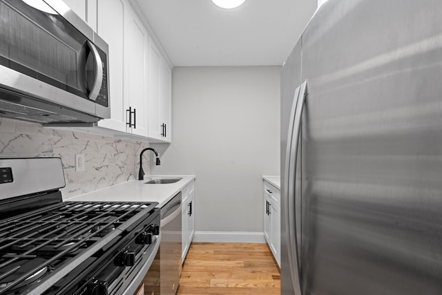 1070 Kelly St, Bronx, NY 10459 - kitchen with appliances with stainless steel finishes, light wood-style flooring, white cabinets, backsplash, and light countertops