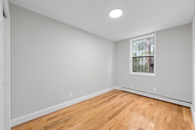 1070 Kelly St, Bronx, NY 10459 - empty room with a baseboard radiator and light wood-style flooring