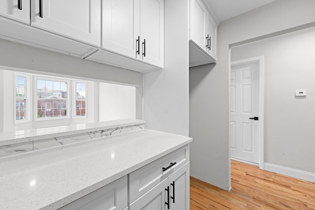 1070 Kelly St, Bronx, NY 10459 - kitchen featuring light wood-style flooring, light stone countertops, and white cabinetry