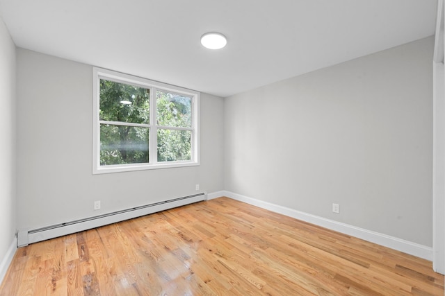 1070 Kelly St, Bronx, NY 10459 - unfurnished room featuring a baseboard heating unit and light wood finished floors