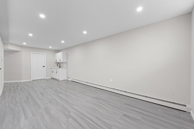 1070 Kelly St, Bronx, NY 10459 - unfurnished living room featuring a baseboard radiator, recessed lighting, and light wood-type flooring