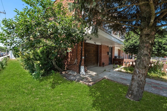 11501 Linden Blvd, South Ozone Park, NY 11420 - view of side of property with brick siding, a garage, and a yard