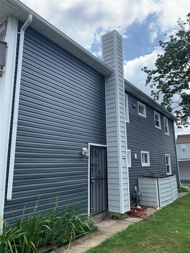 6 2nd Pl, Roosevelt, NY 11575 - rear view of house featuring a chimney