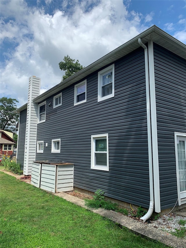 6 2nd Pl, Roosevelt, NY 11575 - view of property exterior with a yard and a chimney