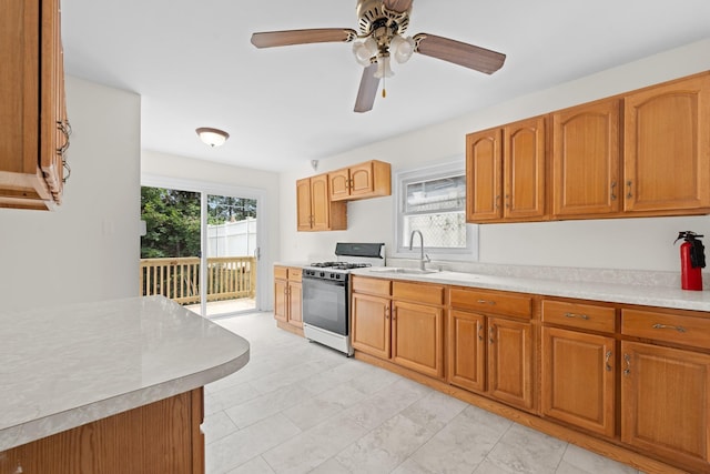 690 Corbalis Pl, Yonkers, NY 10703 - kitchen with gas range oven, light countertops, brown cabinets, and ceiling fan