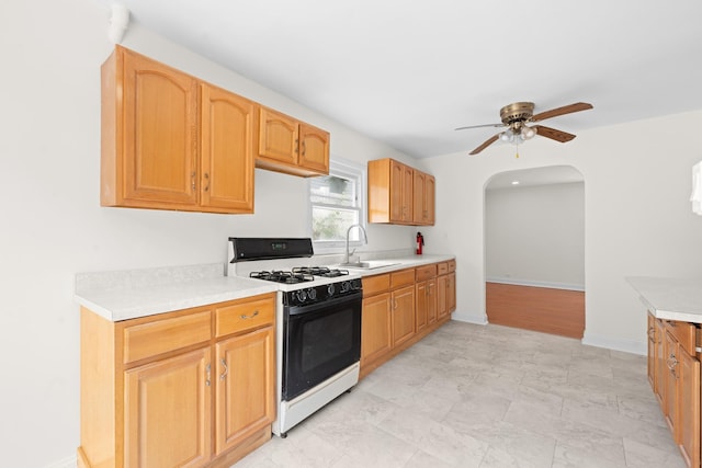 690 Corbalis Pl, Yonkers, NY 10703 - kitchen featuring range with gas stovetop, ceiling fan, arched walkways, and light countertops