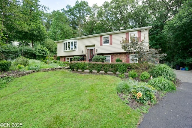 193 Washington Ave, Tappan, NY 10983 - split foyer home featuring a front yard, view of scattered trees, and brick siding