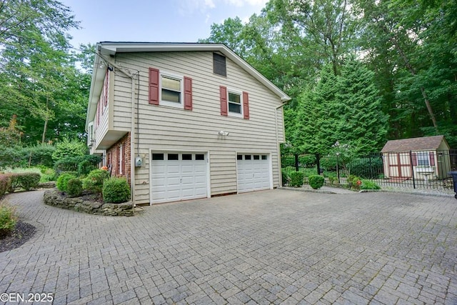 193 Washington Ave, Tappan, NY 10983 - view of side of home featuring a garage, decorative driveway, and a shed