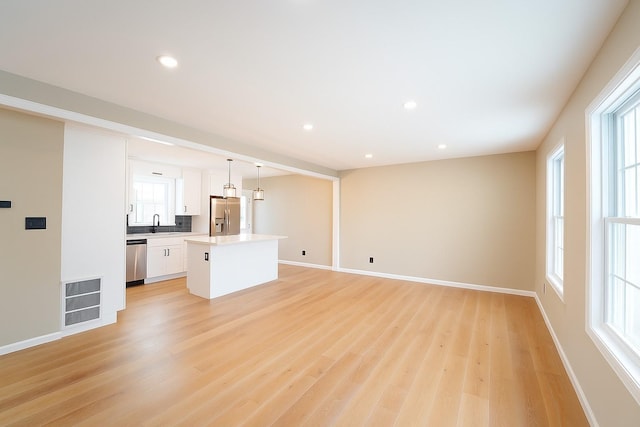 280 Neptune Ave, West Babylon, NY 11704 - unfurnished living room with light wood-style floors, healthy amount of natural light, and recessed lighting
