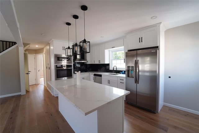 280 Neptune Ave, West Babylon, NY 11704 - kitchen with stainless steel appliances, light wood-style flooring, a kitchen island, light stone counters, and white cabinets