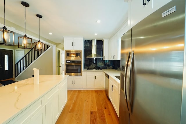 280 Neptune Ave, West Babylon, NY 11704 - kitchen with appliances with stainless steel finishes, wall chimney exhaust hood, light wood-style floors, hanging light fixtures, and white cabinets