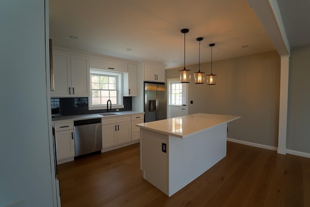 280 Neptune Ave, West Babylon, NY 11704 - kitchen with appliances with stainless steel finishes, dark wood-style flooring, a center island, white cabinetry, and light countertops