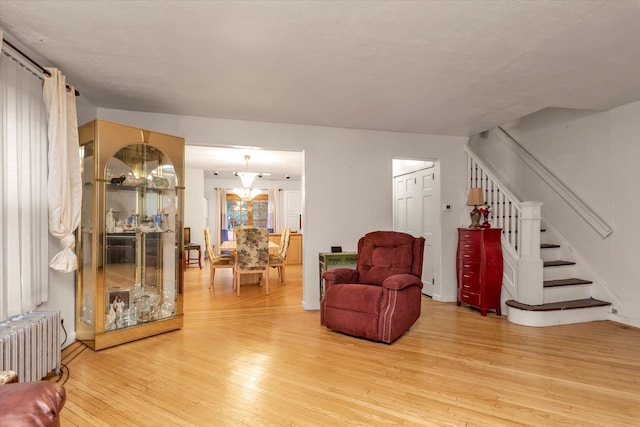 48 Carstairs Rd, Valley Stream, NY 11581 - sitting room with radiator heating unit, light wood finished floors, and stairway