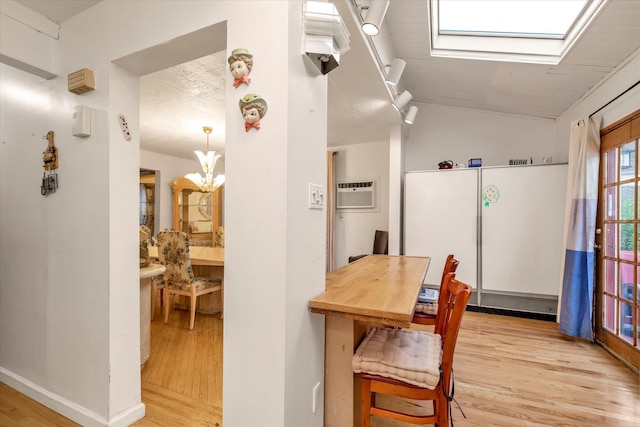 48 Carstairs Rd, Valley Stream, NY 11581 - dining area featuring light wood-style floors, an AC wall unit, a skylight, and vaulted ceiling