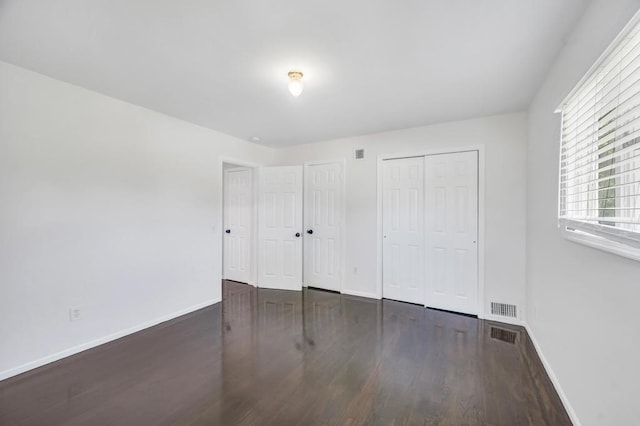 32 Clarkson Rd, Centereach, NY 11720 - unfurnished bedroom featuring wood finished floors and two closets