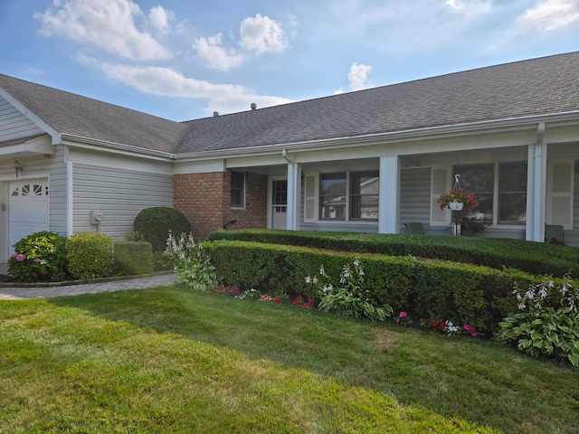 5 Primrose Ln, North Babylon, NY 11703 - property entrance with roof with shingles, a garage, a lawn, and brick siding