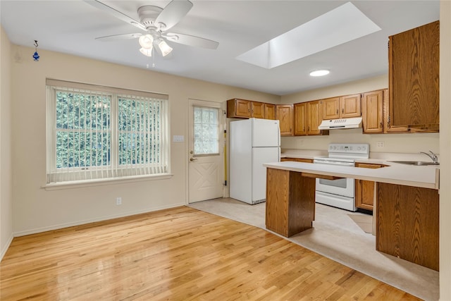 5 Primrose Ln, North Babylon, NY 11703 - kitchen featuring white appliances, under cabinet range hood, a skylight, plenty of natural light, and recessed lighting