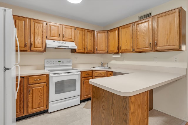 5 Primrose Ln, North Babylon, NY 11703 - kitchen with white appliances, under cabinet range hood, a peninsula, light countertops, and brown cabinets