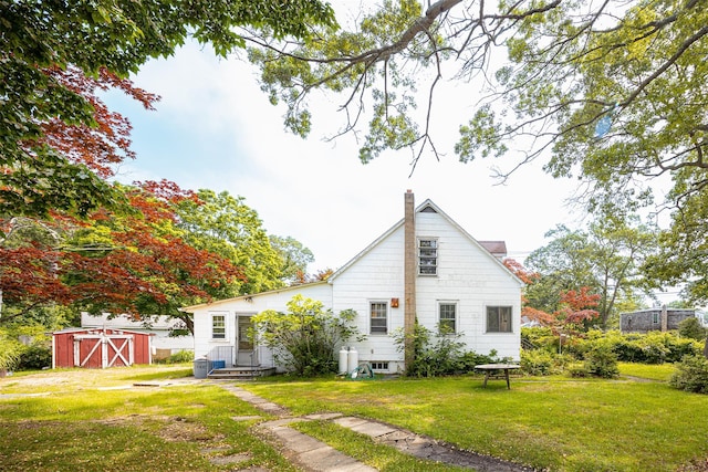 353 W Elm Rd, Mastic Beach, NY 11951 - rear view of property with a storage unit, a yard, a chimney, and entry steps