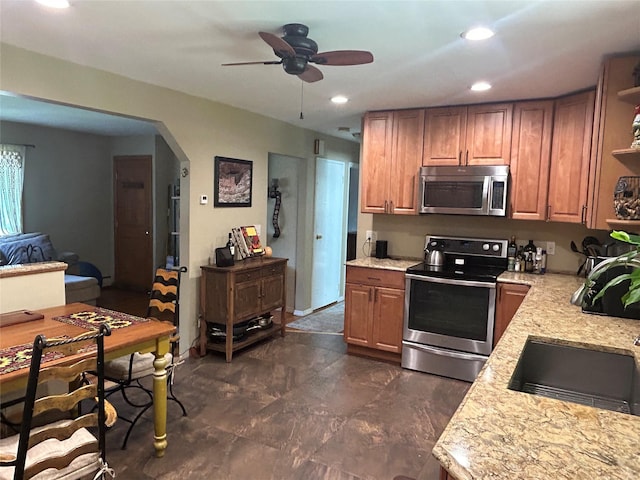 356 Montgomery Ave, West Babylon, NY 11704 - kitchen with stainless steel appliances, ceiling fan, arched walkways, brown cabinetry, and recessed lighting